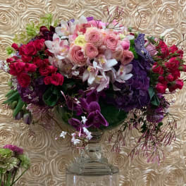 Large bouquet of pink, purple, and white flowers in a clear vase
