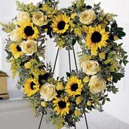 Heart-shaped wreath with sunflowers and cream roses on an easel