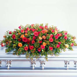 Large spray of pink and orange roses on a casket