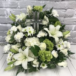 White floral arrangement with a clear cross centerpiece