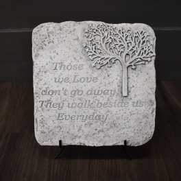 Decorative stone plaque with a tree and memorial quote