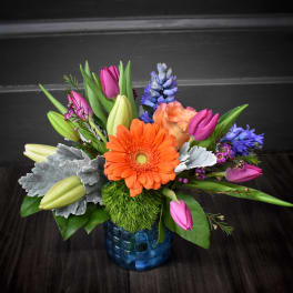 Colorful bouquet with an orange gerbera daisy in a blue vase