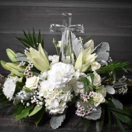 White floral arrangement with a clear glass cross centerpiece