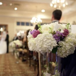 White and purple wedding bouquet in a clear vase