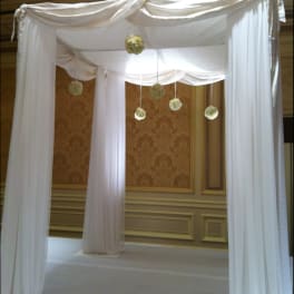 White draped wedding canopy with hanging floral pomanders