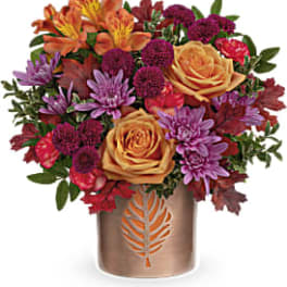 Mixed bouquet of roses and chrysanthemums in a bronze vase