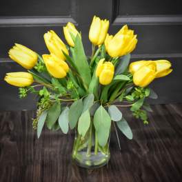 Yellow tulips arranged in a clear glass vase