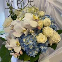 Blue hydrangeas and white roses with white orchids in a bouquet