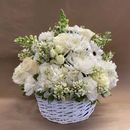White floral arrangement in a white wicker basket