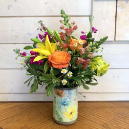 Colorful bouquet of mixed flowers in a floral tin vase