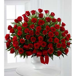 Large bouquet of red roses in a white vase with a red ribbon