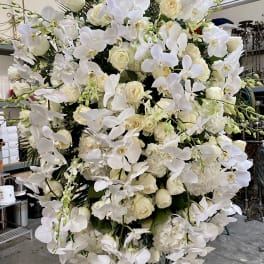 Large white floral standing arrangement with orchids and roses