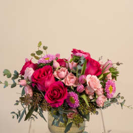 Pink and magenta rose bouquet in a clear glass vase