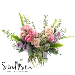 Bouquet of pink and lavender roses in a clear glass vase