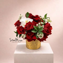 Red rose bouquet with a white orchid in a gold vase