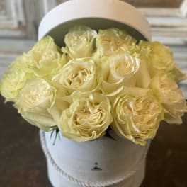 Bouquet of pale yellow roses in a white hatbox