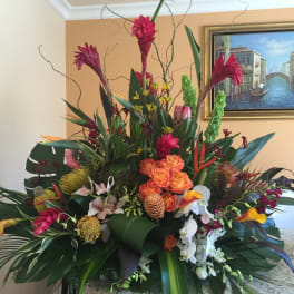 Large tropical flower arrangement with orange roses and orchids