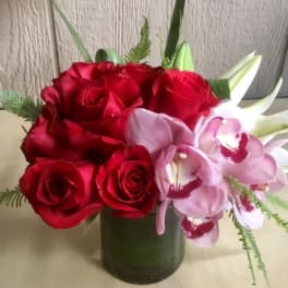Red roses and pink orchids in a green vase