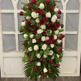 Tall standing arrangement of red and white roses on an easel