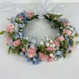 Floral wreath with pink roses and blue baby's breath tied with a white ribbon
