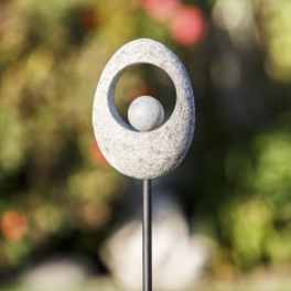White stone garden ornament on a metal stake