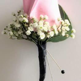 Pink calla lily boutonniere with white filler flowers and black accents