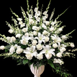 White roses and lilies in a pedestal vase