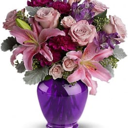Pink and purple bouquet in a purple glass vase