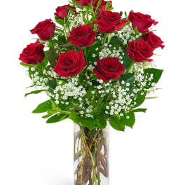 Red roses with baby's breath in a clear glass vase