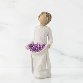 Figurine of a girl holding a tray of purple flowers