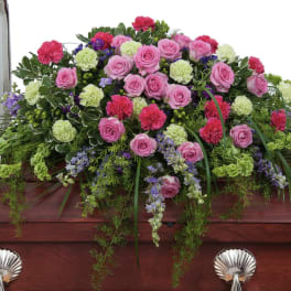 Pink and green floral casket spray with roses and carnations