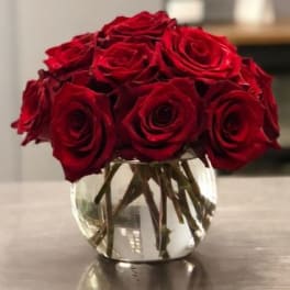 Red roses arranged in a clear glass vase