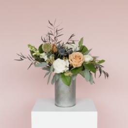 Mixed bouquet of roses and greenery in a silver vase