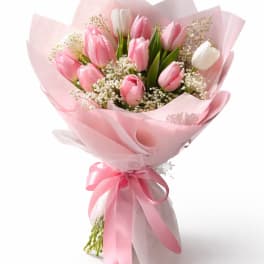 Pink and white tulip bouquet wrapped in pink paper with a ribbon