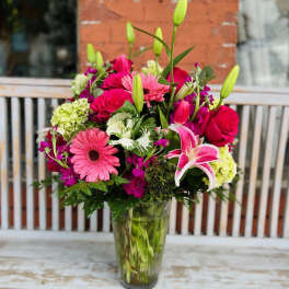 Mixed bouquet of pink and red flowers in a glass vase