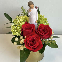 Red roses with green hydrangeas and a figurine in a gold container