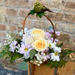 Basket arrangement with pale yellow roses and lavender daisies