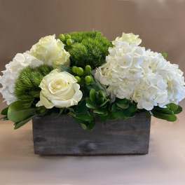 White roses and hydrangeas in a rectangular wooden box