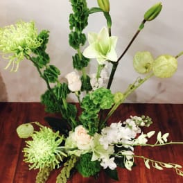Green and white floral arrangement with lilies and chrysanthemums