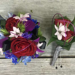 Two floral boutonnieres with red roses and white accents