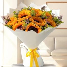 Bouquet of sunflowers wrapped in white paper with a yellow ribbon