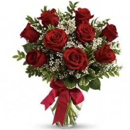 Bouquet of red roses with white filler flowers in a glass vase