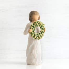 Small figurine of a person holding a green wreath