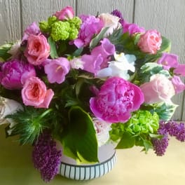 Pink and purple mixed bouquet in a striped white vase