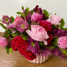 Pink and purple flower arrangement in a white vase