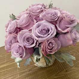 Bouquet of lavender roses in a small wrapped container