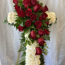 Cross-shaped floral tribute with red roses and white carnations