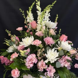 Pink and white mixed flower arrangement in a white basket