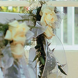 Cream roses with white ribbon on a floral garland