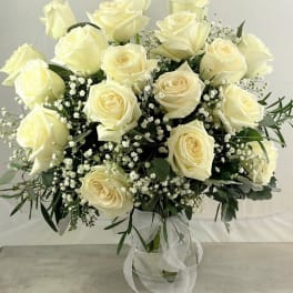Bouquet of cream roses with baby's breath in a glass vase